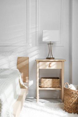 Yatağın yanında lamba olan komodin.