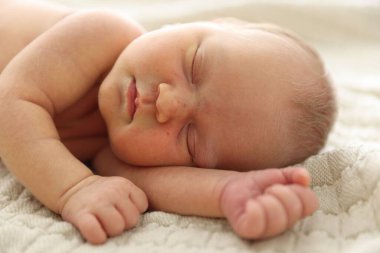 Yeni doğmuş şirin bebek evde yatakta uyuyor.