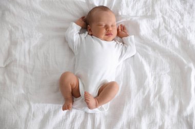 Sevimli yeni doğmuş bebek yatakta uyuyor.