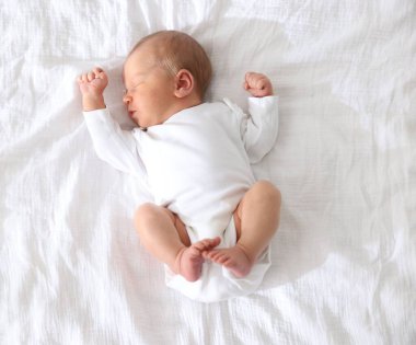 Sevimli yeni doğmuş bebek yatakta uyuyor.