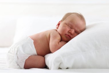 Yeni doğmuş şirin bebek evde yatakta uyuyor.