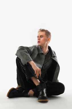 Beyaz arka planda şık ceket giyen yakışıklı genç adam.