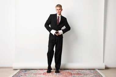 Beyaz arka planda şık giyinen yakışıklı genç adam.