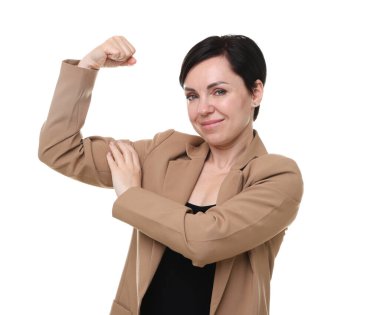 Kuvvet. Takım elbiseli güzel iş kadını beyaz arka planda pazılarını gösteriyor.