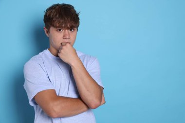 Açık mavi arka planda panik atak geçiren genç bir çocuk. Metin için boşluk