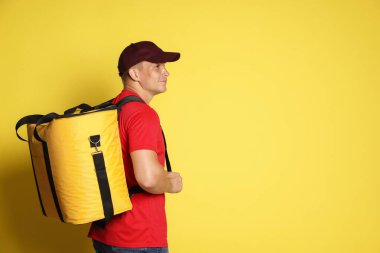 Sarı arka planda termo çantalı kurye, mesaj için yer var. Yemek dağıtım servisi.