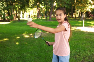 Badminton raketiyle gülümseyen küçük bir kızın portresi.