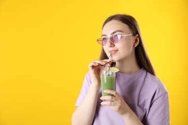 Turuncu arka planda samandan ferahlatıcı içecek içen kadın, mesaj için yer