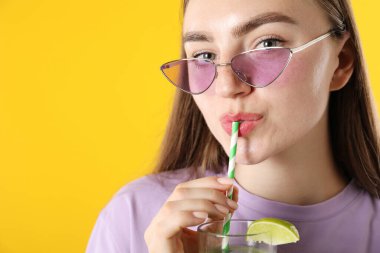 Turuncu arka planda samandan ferahlatıcı içecek içen kadın, mesaj için yer