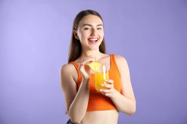 Menekşe arka planında canlandırıcı içecek ve saman olan kadın.