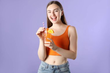 Menekşe arka planında canlandırıcı içecek ve saman olan kadın.