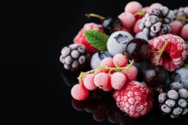 Siyah masada bir sürü farklı donmuş dut var. Yakın plan. Metin için boşluk