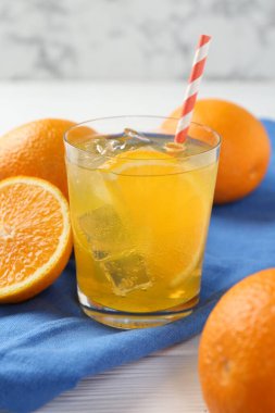 Portakal dilimli soda ve beyaz ahşap masada taze meyve, yakın plan.