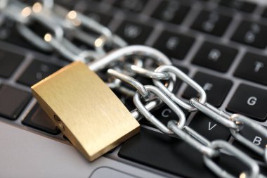 Siber güvenlik. Bilgisayarında zincir olan metal asma kilit, yakın plan.