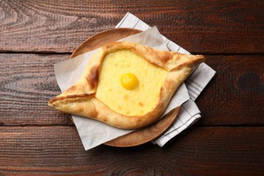 Tahta masadaki peynirli ve yumurtalı leziz khachapuri.