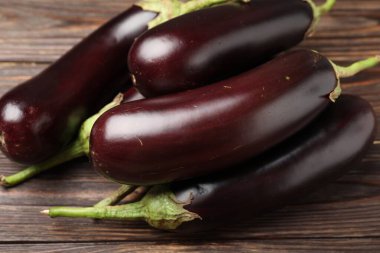 Pek çok olgun patlıcan ahşap masada, yakın plan