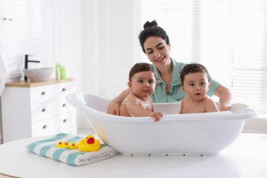 Annem ikiz çocuklarını evde yıkıyor.