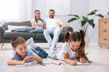 Çocuklar evlerinde sıcak zeminde anne babalarının yanına resim çiziyorlar, seçici bir şekilde. Isıtma sistemi