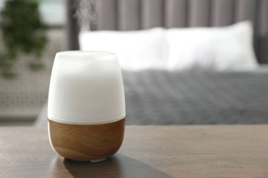 Ahşap masa üzerinde modern aroma lambası. Metin için boşluk