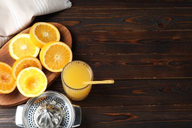 Taze sıkılmış portakal suyu, meyve suyu ve meyve sıkacağı ahşap masada, manzaranın üstünde. Metin için boşluk
