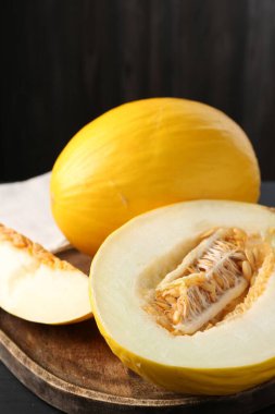 Kesilmiş ve olgunlaşmış karpuzlar siyah ahşap masada, yakın plan.