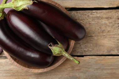 Tahta masanın üstünde bir sürü olgun patlıcan var.