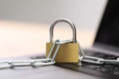 Siber güvenlik. Bilgisayarında zincir olan metal asma kilit bulanık arka planda, yakın plan