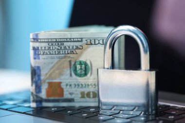 Siber güvenlik. Metal asma kilit ve dolar dizüstü bilgisayarda, yakın plan.