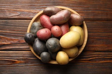 Tahta masadaki kasede farklı patates türleri, üst manzara.