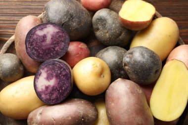 Tahta masadaki kasede farklı tipte patatesler var.