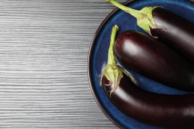 Siyah ahşap masada bir sürü olgun patlıcan, üst manzara. Metin için boşluk