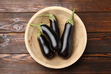 Tahta masadaki kasede taze patlıcanlar.