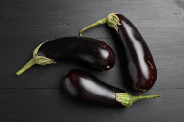 Siyah ahşap masada taze patlıcanlar.