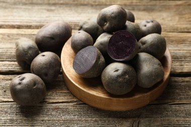 Tahta masada taze, mor patatesler, yakın plan.