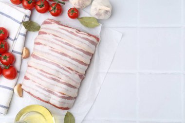 Bir parça çiğ et, domates ve baharatlar beyaz fayanslı masada, düz yerde. Metin için boşluk