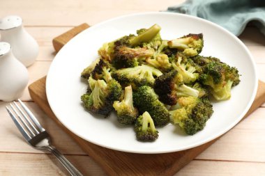 Lezzetli kızarmış brokoli ve çatal açık ahşap masada, yakın plan.