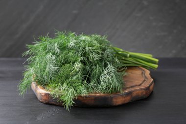 Siyah ahşap masada taze dereotu var, yakın plan.