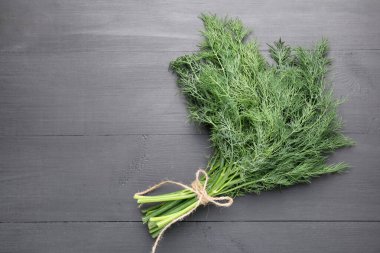 Siyah ahşap masanın üstünde taze dereotu var. Metin için boşluk