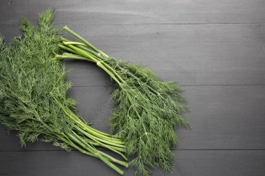 Siyah ahşap masada bir sürü taze dereotu var. Metin için boşluk