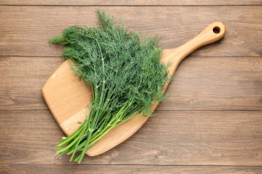 Tahta masada taze dereotları var.