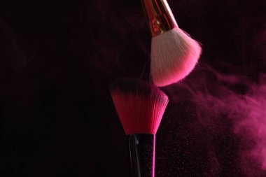 Siyah arka planda pembe göz farlı makyaj fırçaları, yakın plan