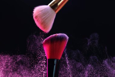 Siyah arka planda pembe göz farlı makyaj fırçaları, yakın plan