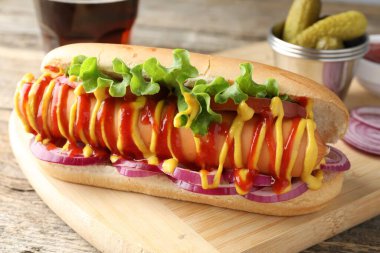 Lezzetli sosisli sandviç, ahşap masada soda ile servis edilir, yakın plan.