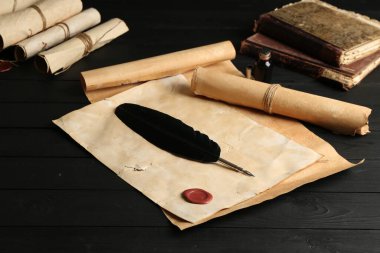 Birçok eski tomarlar, tüy ve mürekkep siyah ahşap masa, yakın çekim