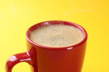 Sarı arka planda, fincanda Aromatik kahve, yakın plan.