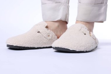 Beyaz arka planda yumuşak terlikli kadın, yakın plan.