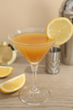 Bardakta lezzetli limon kokteyli ve ahşap masada barmen ekipmanı, yakın plan.