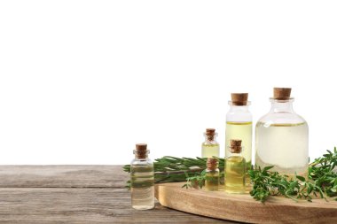 Gerekli yağlar, kekik ve biberiye ahşap masada arka planda.