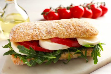 Peynirli, domatesli ve roka soslu lezzetli bir sandviç.