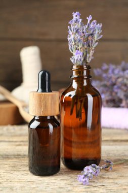 Lavanta özü yağ ve çiçekler ahşap masada.